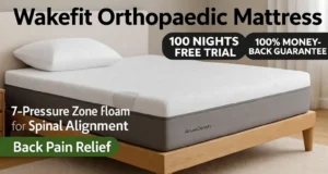 The Wakefit Orthopaedic Mattress displayed on a wooden bed frame in a stylish bedroom, showcasing its three-layer memory foam design with 7-pressure zone foam for spinal alignment. Text overlays highlight '100 Nights Free Trial,' '100% Money-Back Guarantee,' '7-Pressure Zone Foam for Spinal Alignment,' and 'Back Pain Relief.' A firm pillow for side sleepers and a soft bed pillow are placed on top, with a nightstand and lamp in the background.