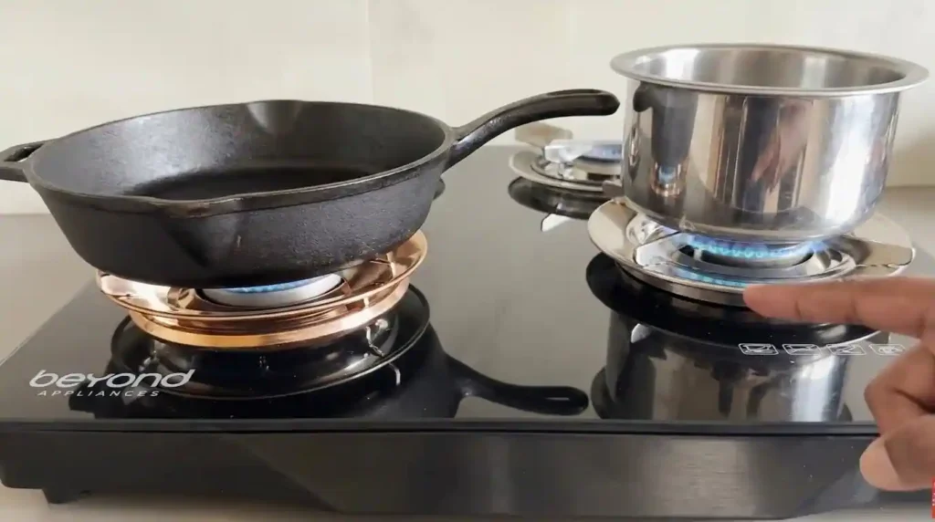 Beyond Appliances Quantum Gas Stove heating a cast-iron pan and stainless-steel vessel over stable blue flames.
