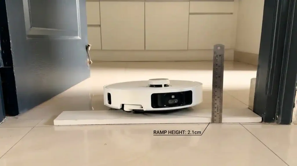 Robot vacuum cleaner crossing a 2.1 cm door threshold during a real home performance test.